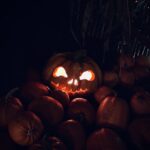 a pumpkin with glowing eyes surrounded by pumpkins
