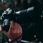 person holding black canon dslr camera