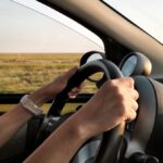 person with white watch driving car