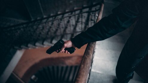 Person in Black Jacket Holding Black Gun