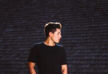 Addio a loghi e uniformi: adesso nell’abbigliamento si cerca l’ultra-personalizzazione man standing near concrete bricks