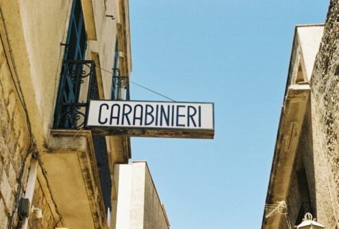 A street sign hanging from the side of a building