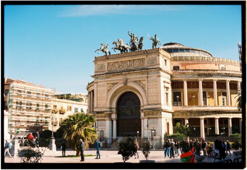 Historic Teatro Politeama in Palermo, Italy, captured on a sunny day with vibrant street activity.