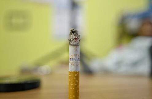 A lit cigarette with some ash.