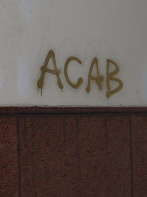 graffiti on the side of a building reads acab