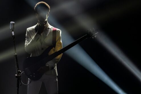 a man holding a guitar in front of a microphone