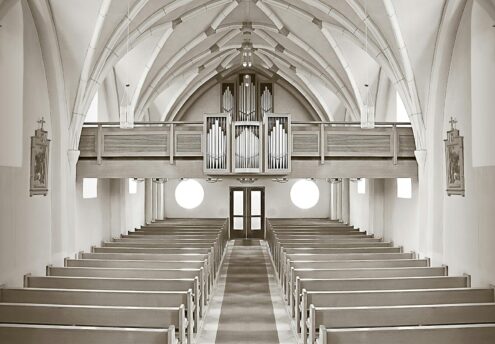Symmetrical church interior highlighting architectural details and organ pipes.
