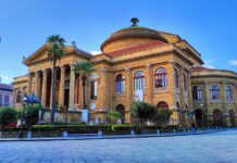 La scalinata del Teatro Massimo si tinge di rosso contro la violenza di genere a large building with a dome on top of it