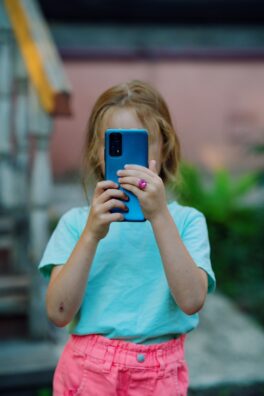 a little girl taking a picture with her cell phone