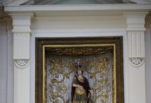 Ruba in chiesa la borsa di un’anziana, denunciata 34enne Luxurious altar in Urbino's church showcasing intricate gold designs and religious sculptures.