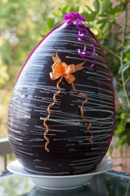 A giant chocolate Easter egg with colorful ribbons, perfect centerpiece.