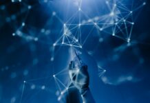 Nominato il responsabile per la “transizione digitale”” del Comune di Campobello di Licata A robotic hand reaching into a digital network on a blue background, symbolizing AI technology.