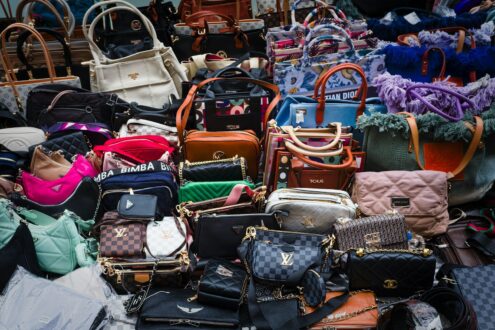 a pile of purses and handbags sitting next to each other
