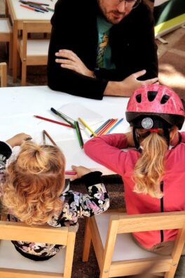 Children drawing at a table with an adult