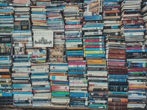 A vibrant collection of stacked books creating a visually arresting pattern in a Dhaka bookstore.