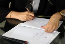 Concorso Notai 2024, Codici: pronti a tutelare i candidati al processo a person writing on a piece of paper