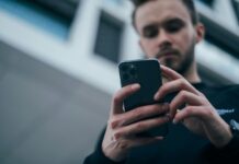 Canicattì, realizza app gratuita per i turni idrici: Aica lo diffida, Restivo presenta interrogazione per chiarimenti man wearing black sweater using smartphone