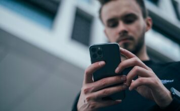 Canicattì, realizza app gratuita per i turni idrici: Aica lo diffida, Restivo presenta interrogazione per chiarimenti man wearing black sweater using smartphone