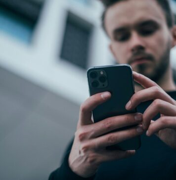 Canicattì, realizza app gratuita per i turni idrici: Aica lo diffida, Restivo presenta interrogazione per chiarimenti man wearing black sweater using smartphone