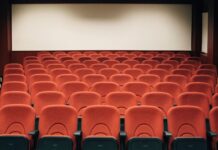 Il pluripremiato Daniele Ciprì ospite del Sicani Cinema Experience 2026 A spacious theater with empty red seats and a large screen, ready for the next audience.
