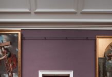 Campobello di Licata, “il sacro ed il profano”: mostra di pittura Art gallery in Rouen, France featuring large paintings and a curator seated in doorway.