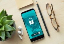 DigitalValut: dall’Italia un’app pensata per chi vuole davvero proteggere la propria privacy A smartphone displaying a security lock icon on a wooden desk with a succulent